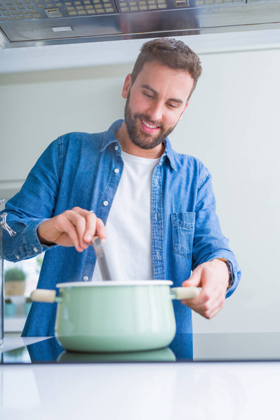 Красивый мужчина готовит макароны дома - Фото, изображение