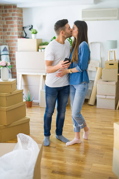 Fiatal pár költözött egy új házat, smartphone mosolygó nagyon boldog az új lakás - Fotó, kép