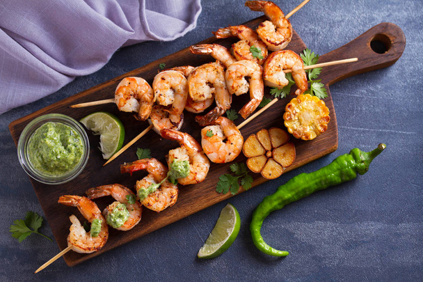 Cilantro lime grilled shrimps. Shrimps on skewers with garlic butter sauce. View from above, top studio shot - Foto, Imagen