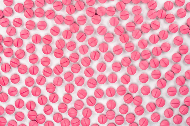 Pilules rondes de couleur rose sur fond blanc avec mise au point sélective. Pilules qui ressemblent à de l'ecstasy
 - Photo, image