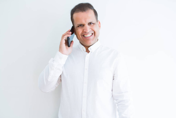 Middle age man calling using smartphone with a happy face standing and smiling with a confident smile showing teeth - Foto, imagen