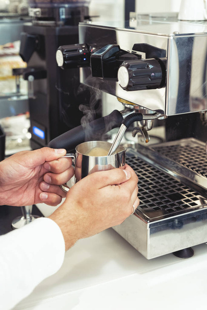 Kahvinkeitin ja barista valmistavat kahvia kahvilassa
 - Valokuva, kuva