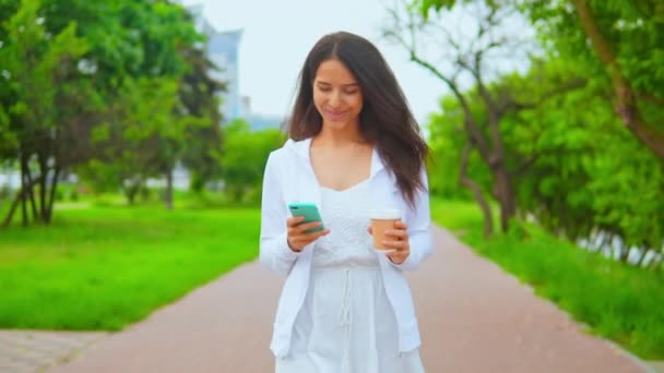 woman walking messaging on smartphone - Footage, Video