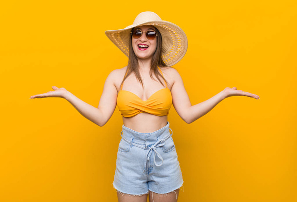 Young caucasian woman wearing a straw hat, summer look showing a welcome expression. - Foto, Imagem