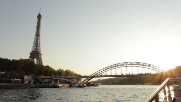 Zachód słońca nad Sekwaną, podczas gdy statek przechodzi pod mostem w pobliżu wieży Eiffla-Paryż, Francja. - Materiał filmowy, wideo
