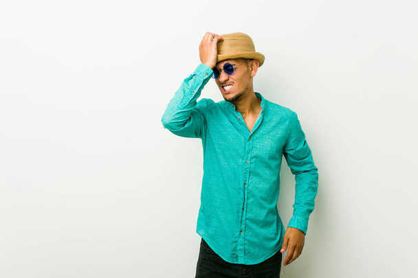 Jeune homme hispanique portant des vêtements d'été oubliant quelque chose, frappant le front avec la paume et fermant les yeux
. - Photo, image