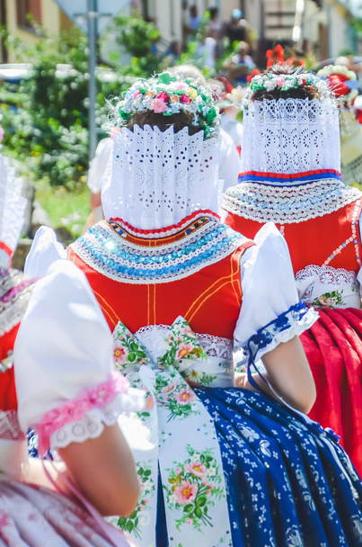 伝統的なチェコの民間伝承の衣装でパレード中の若い女性。チェコの南モラヴィアで撮影。モラヴィアのモチーフ。お祝い, 伝統 - 写真・画像