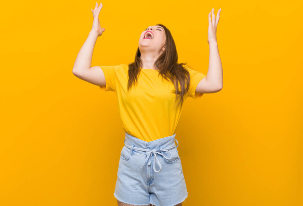 Jovem adolescente vestindo uma camisa amarela gritando para o céu, olhando para cima, frustrado
. - Foto, Imagem