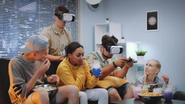 Dwóch młodych mężczyzn gra online w wirtualnej rzeczywistości okulary, jeden facet wygrywa bitwę - Materiał filmowy, wideo