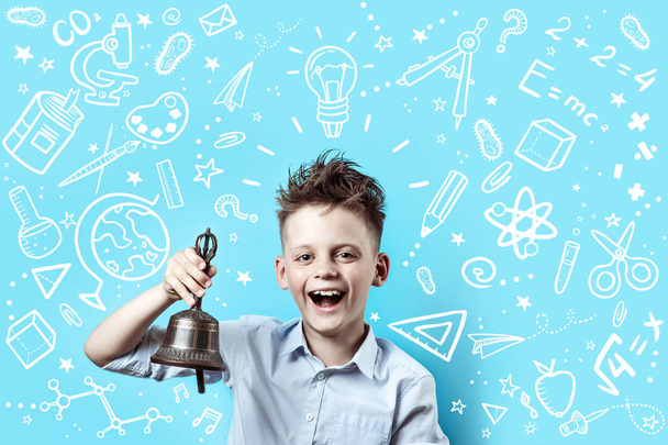 a boy in a light shirt smiles and rings a bell. Around it are various school icons on blue background - Foto, Bild