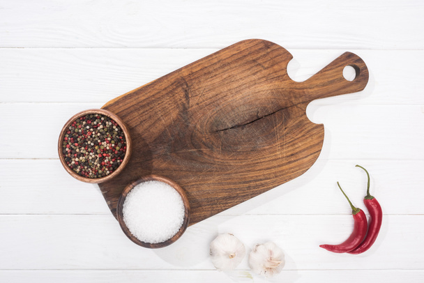 a vágódeszka, chili paprika, só, a garlics és a fűszerek felülnézete  - Fotó, kép