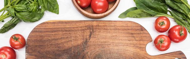 панорамний знімок дерев'яної дошки, зелені та вишневих помідорів
 - Фото, зображення