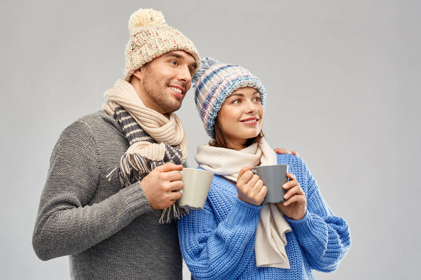 happy couple in winter clothes with mugs - Foto, Imagen