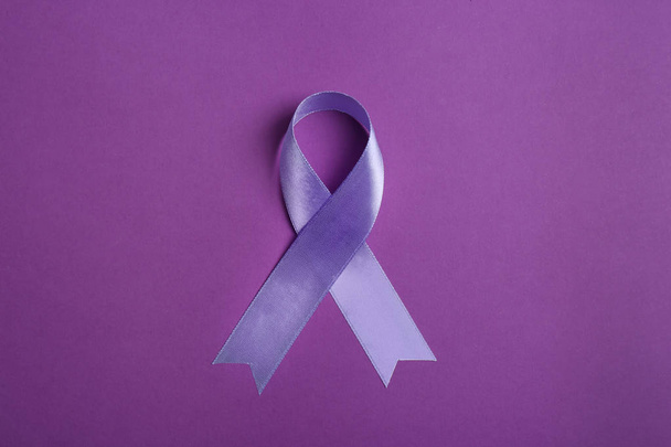 Purple awareness ribbon on color background, top view - Foto, imagen
