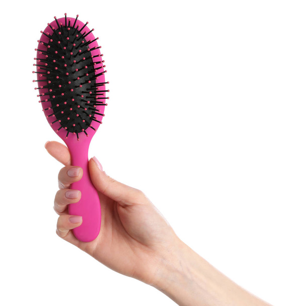 Woman holding hair brush against white background, closeup - Zdjęcie, obraz