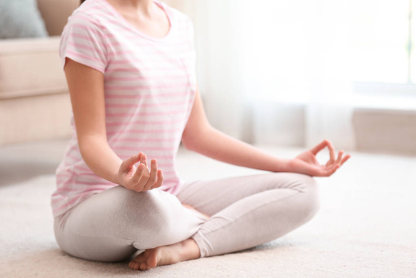 Young woman meditating on floor at home, closeup. Zen concept - Фото, зображення