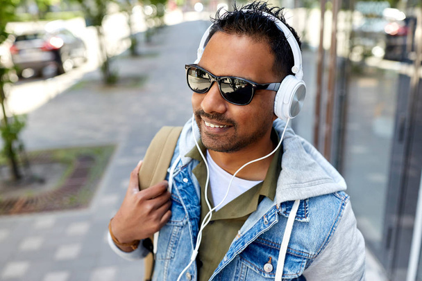 indian man in headphones with backpack in city - Photo, Image