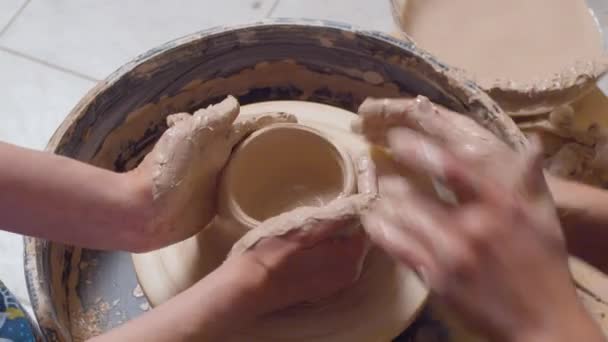 Mãos de mulher que fazem um pote em uma roda de oleiros
 - Filmagem, Vídeo