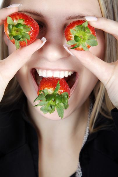 Blonde girl eating strawberries - 写真・画像
