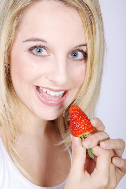 Hermosa boca femenina con dientes blancos comiendo fresas
 - Foto, Imagen