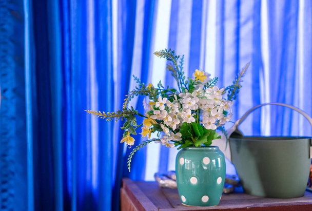 Поддельные цветы в вазе на деревянном столе
 - Фото, изображение