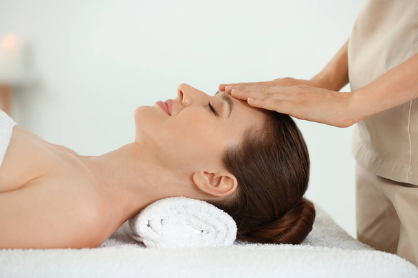 Beautiful young woman enjoying massage in spa salon - Photo, image