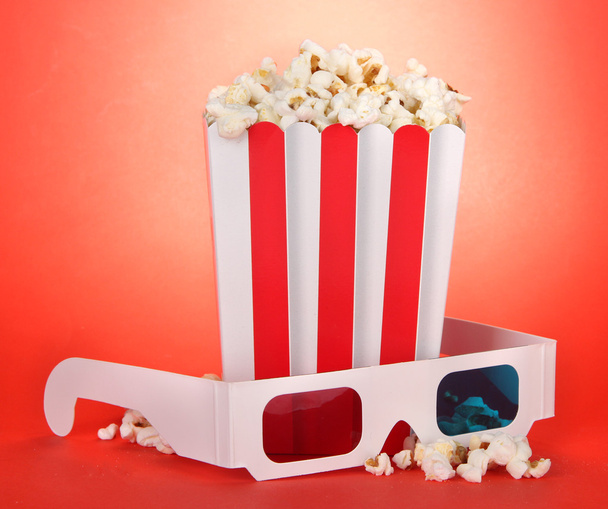 Popcorn and 3D glasses on red background - Фото, зображення