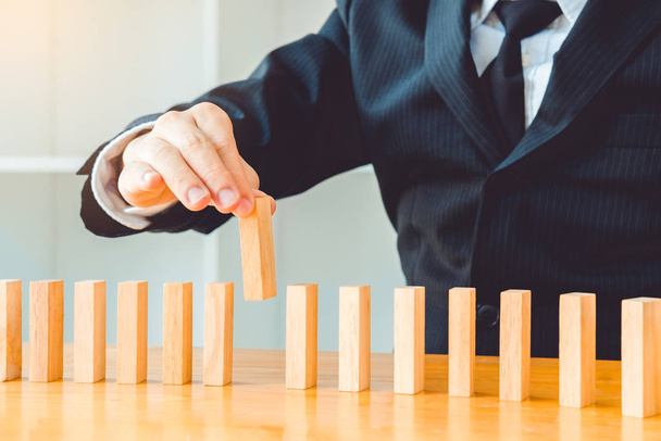 Businessman plan and strategy in business Domino Effect Problem  - Fotoğraf, Görsel