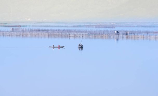 kleine Fischerboote bewegen die Fischerei in der Lagune einer der größten Lagunen in Zentralvietnam - Foto, Bild