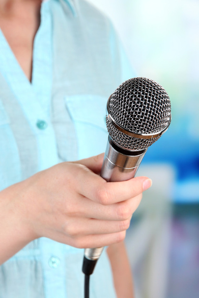 Female with microphone on room background - Fotoğraf, Görsel