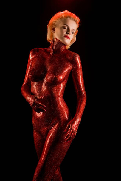 Nude blonde covered with red color in the dark - Foto, immagini