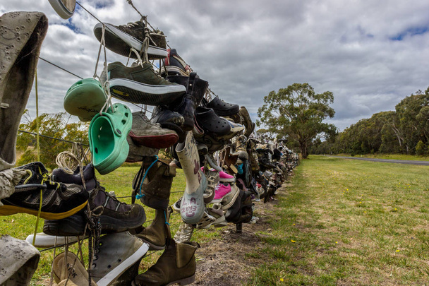 Régi cipők egy kerítésen egy ausztrál út mellett. turista tette a régi cipő a kerítés - Fotó, kép