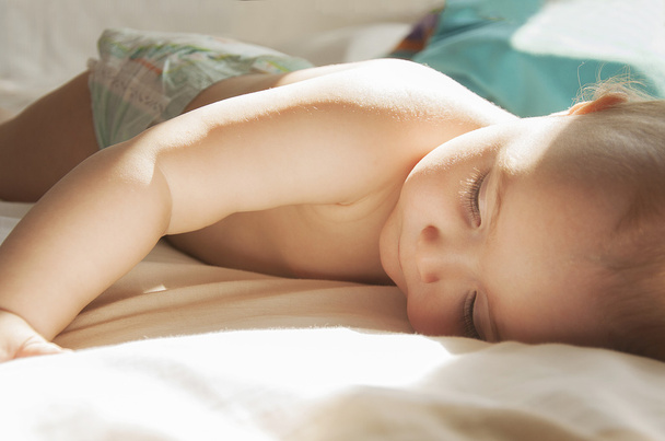 dziecko, leżąc na łóżku w pampersy - Zdjęcie, obraz