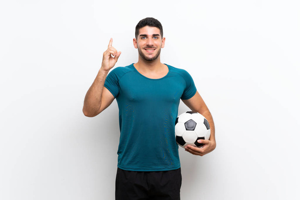 Όμορφος νέος ποδοσφαιριστής άνθρωπος πάνω από απομονωμένο λευκό τοίχο δείχνοντας μια υπέροχη ιδέα - Φωτογραφία, εικόνα