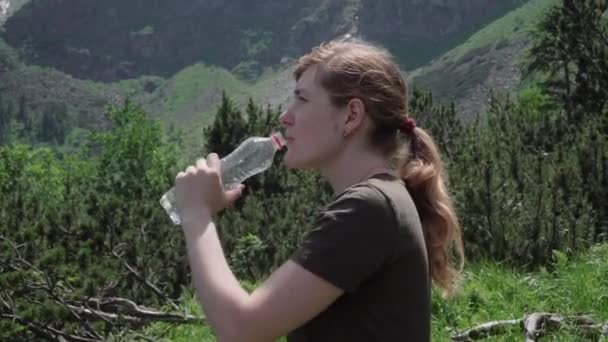 junges Mädchen trinkt Wasser nach dem Bergsteigen - Filmmaterial, Video
