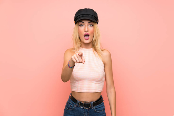Young blonde woman with hat surprised and pointing front - Фото, изображение