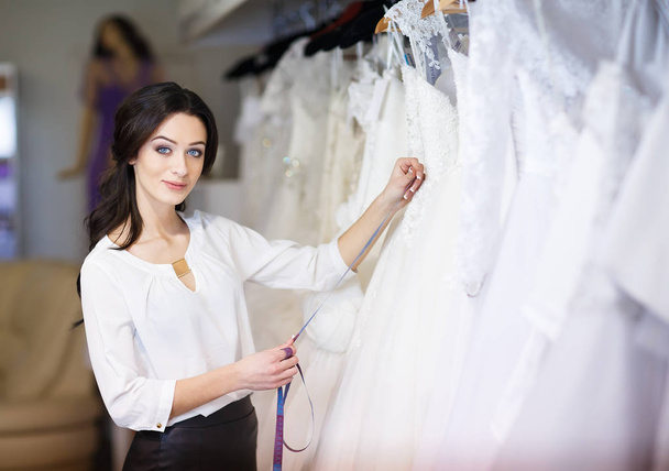 dealer consultant in the background of wedding dresses - Fotoğraf, Görsel