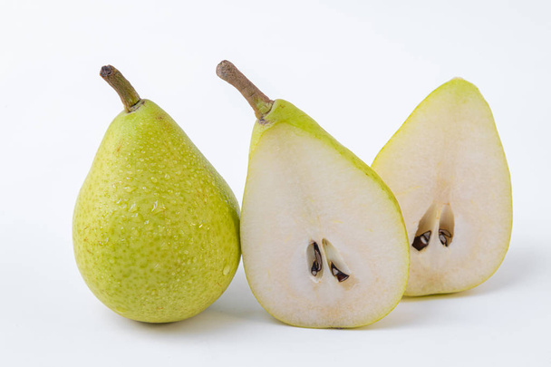 A pear in two halves accompanied by a whole pear isolated on a white background - Green and sweet pears - Photo, Image