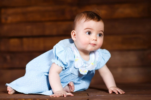 Cute little girl on a wooden background. - Valokuva, kuva