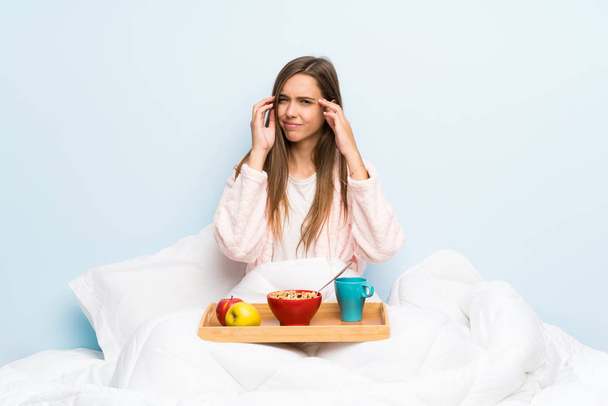 Młoda kobieta w szlafroku ze śniadaniem nieszczęśliwy i sfrustrowany czymś. Negatywna ekspresja twarzy - Zdjęcie, obraz