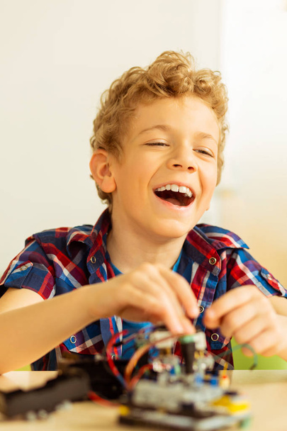 Joyful happy boy enjoying a lot robotics - Foto, afbeelding