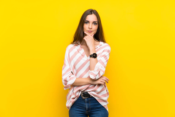 Young woman over isolated yellow background thinking - Fotó, kép