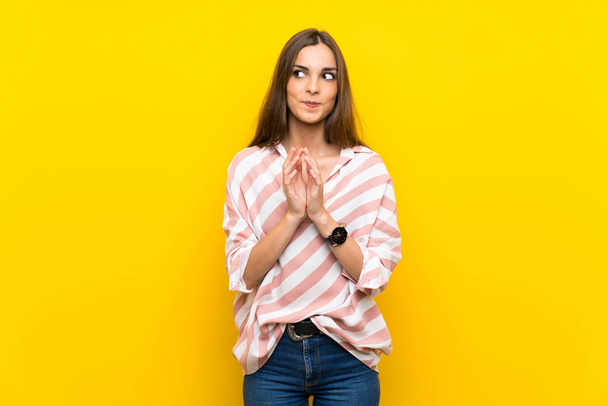 Young woman over isolated yellow background scheming something - Photo, image