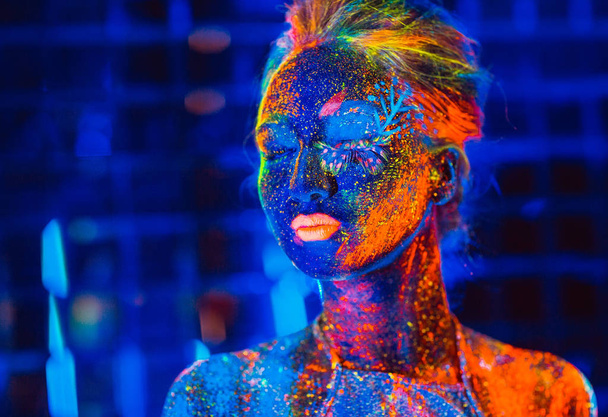 Portrait of a girl painted in fluorescent powder - Foto, Imagem