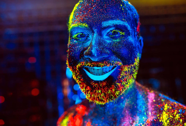 Portrait of a bearded man painted in fluorescent powder. - Foto, immagini