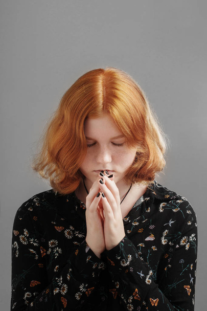  girl with  red hair folded her hands in prayer - Фото, изображение