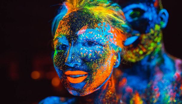 Portrait of a pair of lovers painted in fluorescent powder. - Fotoğraf, Görsel