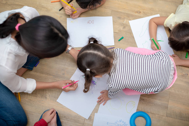 Группа дошкольников и педагогов рисуют на бумаге в искусстве c
 - Фото, изображение