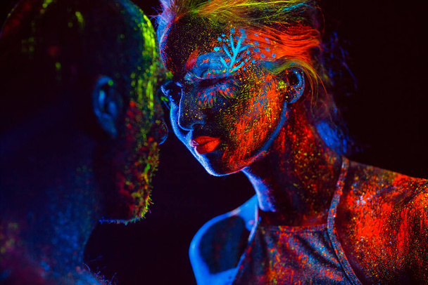 Portret pary kochanków, malowane w proszku fluorescencyjnym. - Zdjęcie, obraz