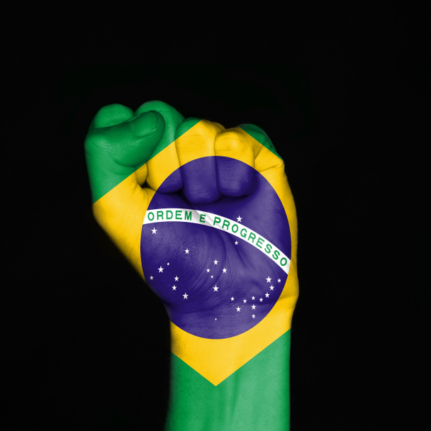 Bandera de Brasil a puño sobre fondo negro. Símbolo de fuerza
. - Foto, imagen
